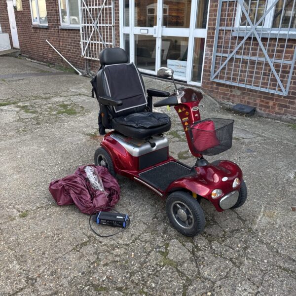 Red Shoprider mobility scooter parked outside.