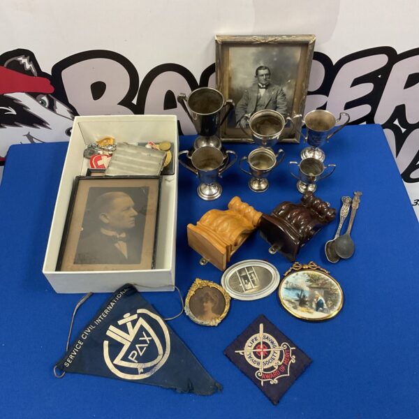 Vintage curios tray with antique photo frames and trophies.