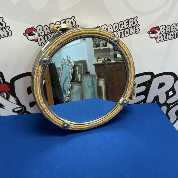 Vintage porthole mirror with rope detailing for nautical decor.