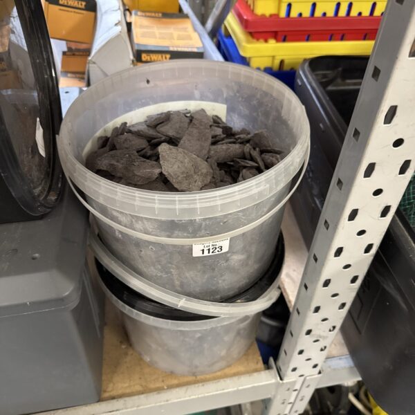 Two tubs of dark grey slate chippings for garden landscaping.