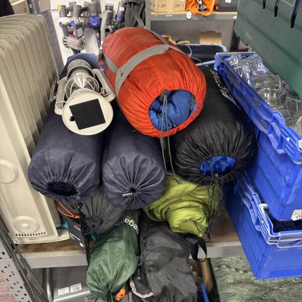 Camping equipment bundle including sleeping bags and chairs.