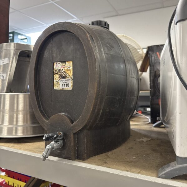 Plastic barrel drinks dispenser with tap for serving beverages.