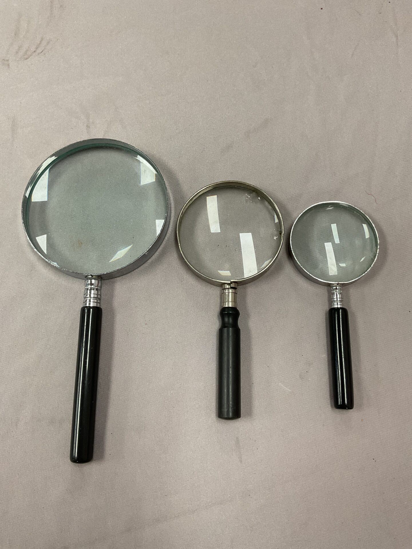 805 Set of three magnifying glasses (one has chips)
