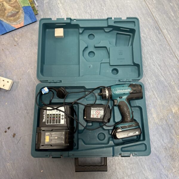 Open Makita cordless drill set case with drill and charger.