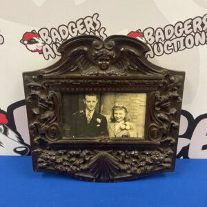 Ornate vintage photo frame with a portrait inside.