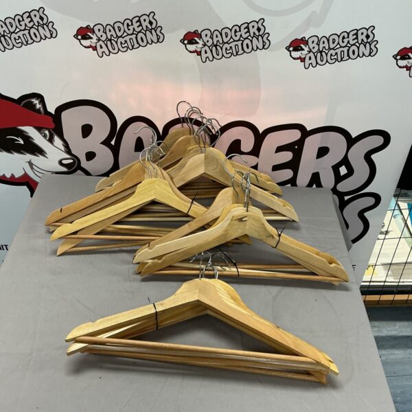 Lot of vintage wooden clothes hangers for coat and garment storage.