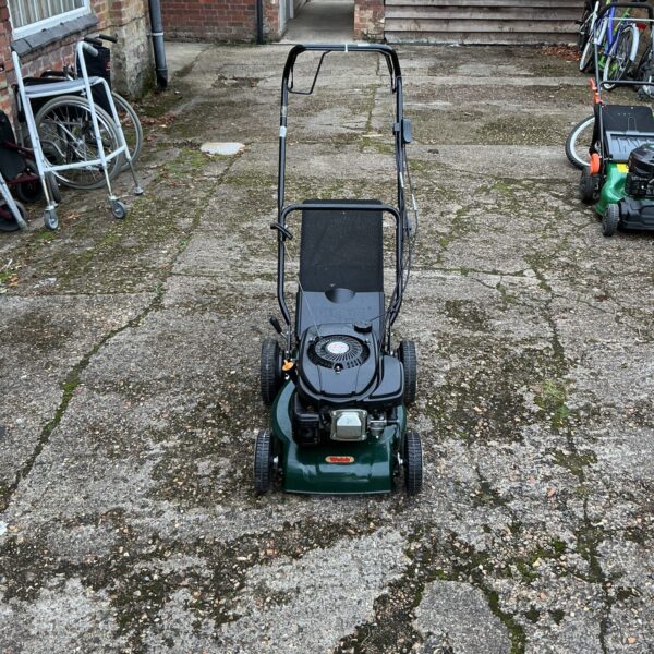 Side view of a used Hawksmoor petrol lawnmower with push handle.