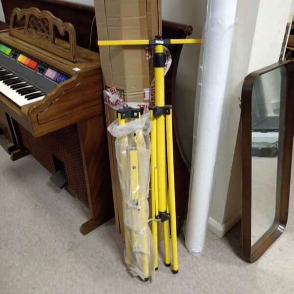 Pair of yellow site light tripods with a keyboard in the background.