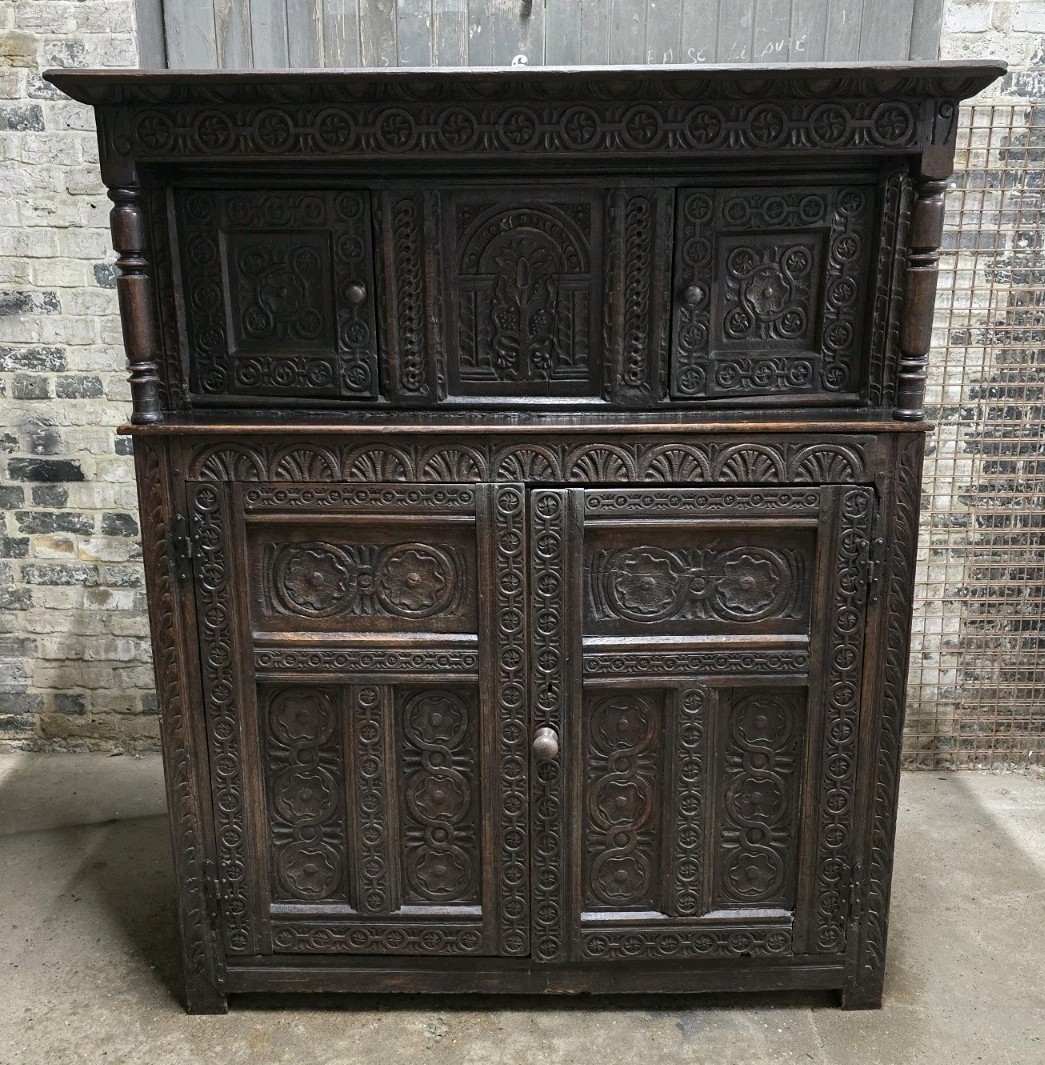 Front view of a large antique carved wood cabinet.