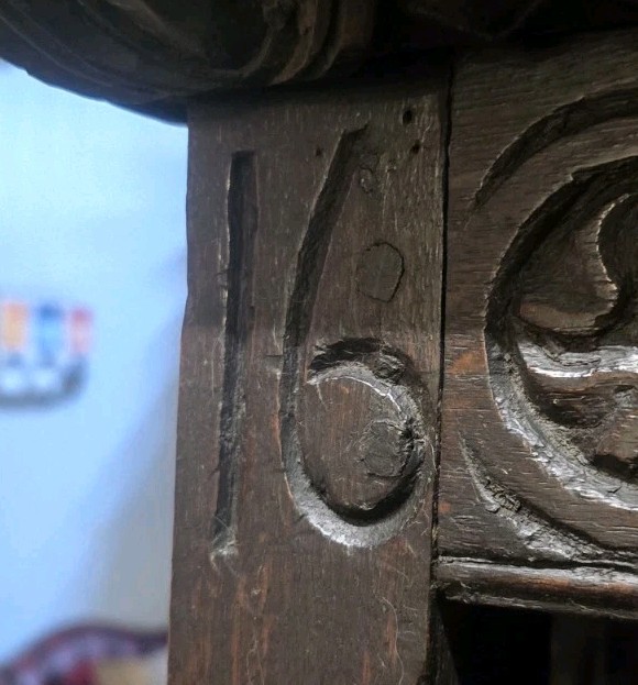 Detailed antique carved wood panel with floral relief carving.