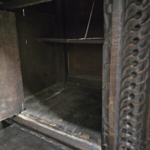 Interior view of antique carved wooden box with detailed carving.