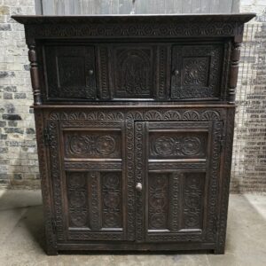 Antique 17th-century oak wardrobe with detailed carved panels and a classic design.