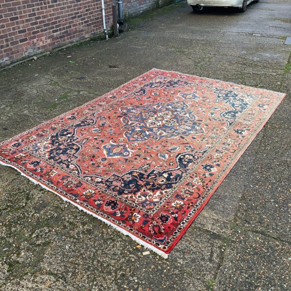 Large antique red Turkish Sarouk rug with intricate floral design.