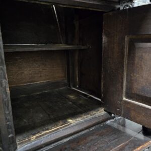 Interior view of antique wooden cabinet with shelving.