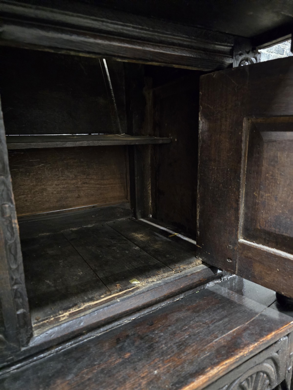 Interior view of antique wooden cabinet with shelving.