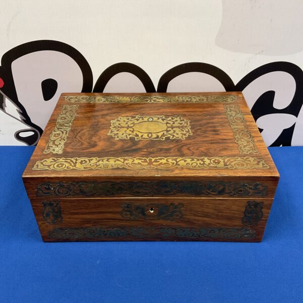 Front view of antique wooden inlaid box with brass detailing.