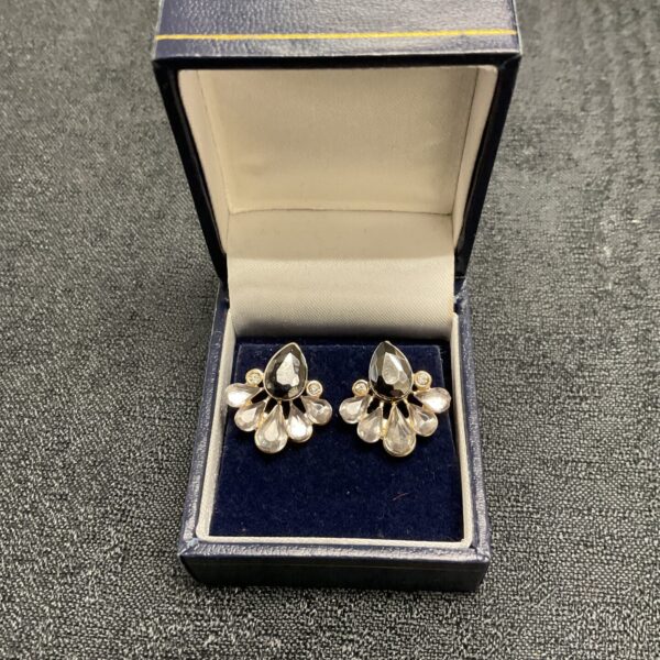 Vintage Art Deco sapphire and Whitestone teardrop earrings on display.