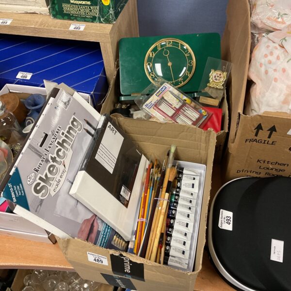 Mixed lot of artist’s materials, vintage clock, and camera lens.