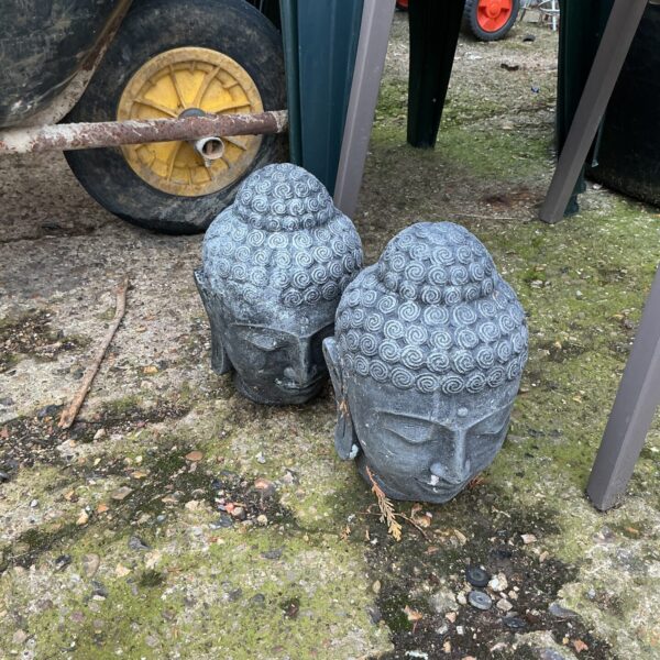 Weathered Buddha garden ornaments in an outdoor setting.