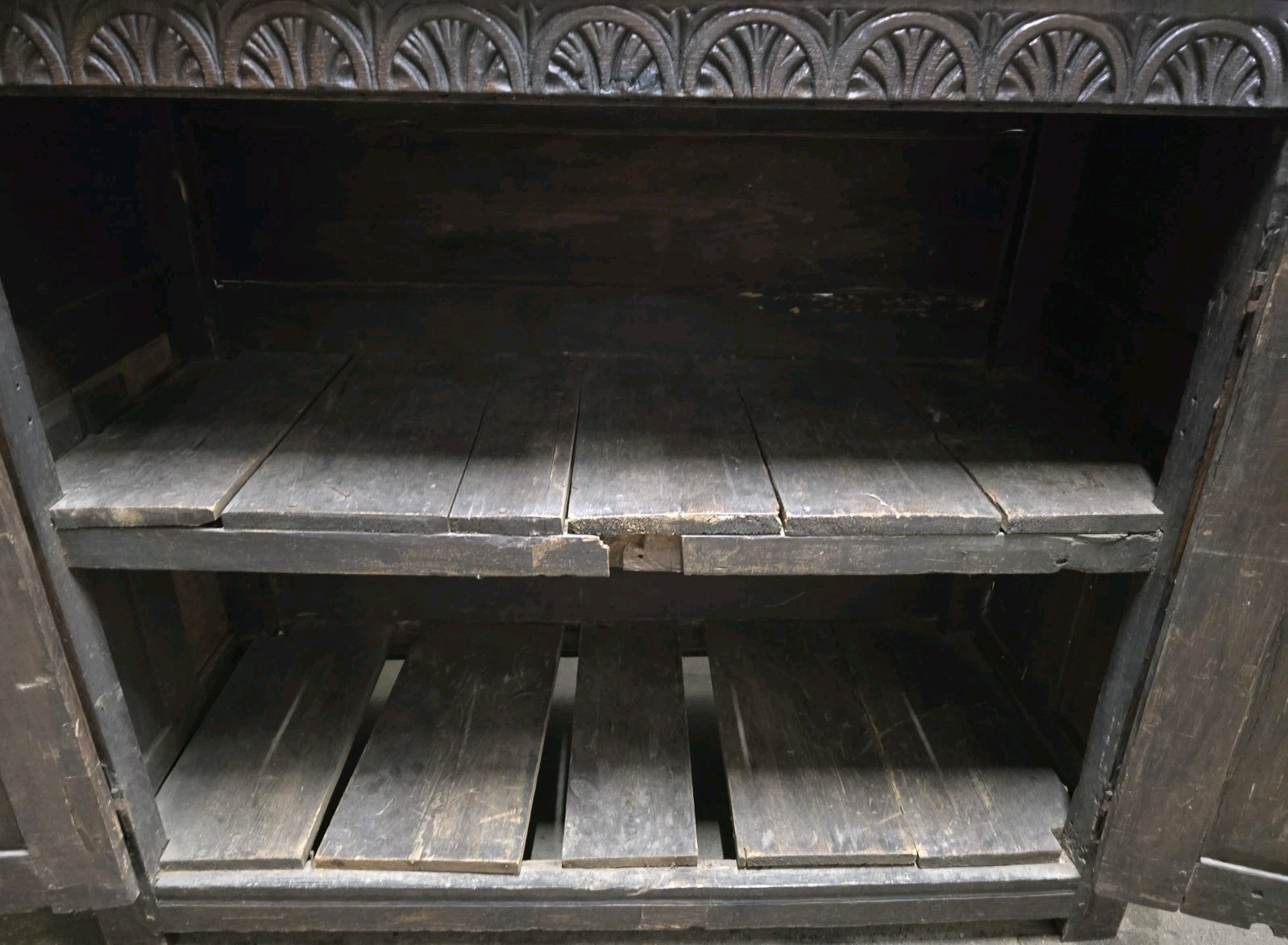 Interior view of the antique cabinet with wooden shelves.