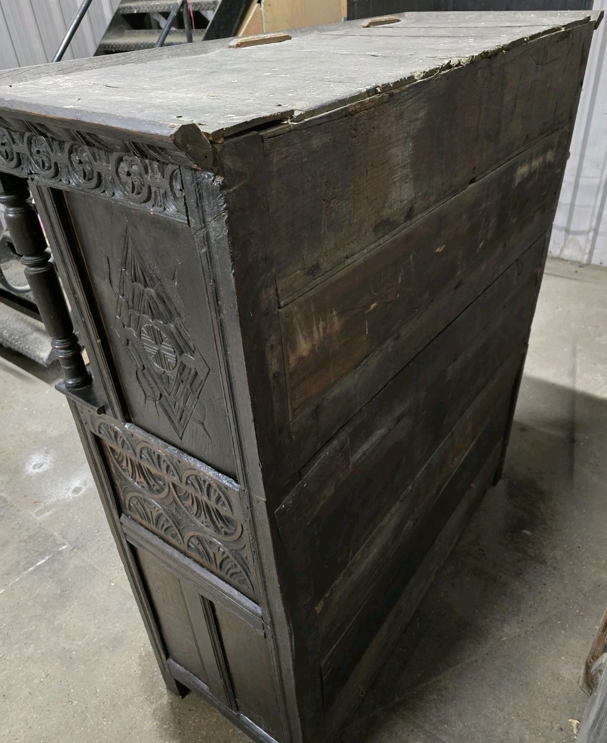 Side view of the antique cabinet with carved detailing.