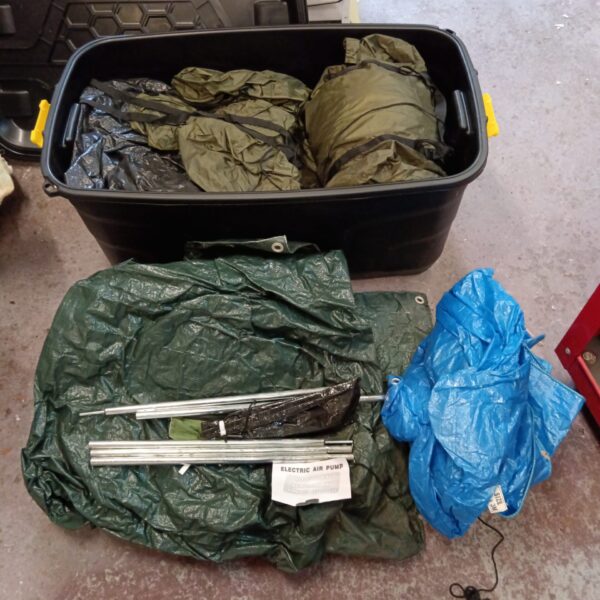 Large crate filled with camping equipment, including a tent.