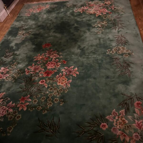 Large green Chinese Art Deco rug with floral design.