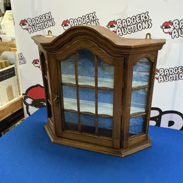 Vintage dark wood wall hanging cabinet with glass door for display.