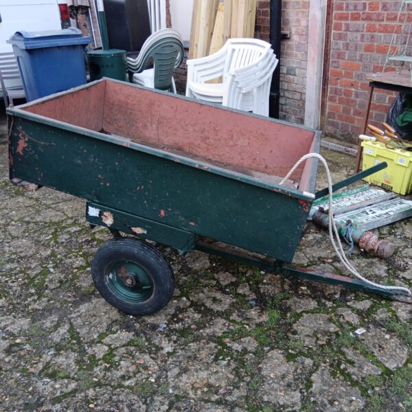 Vintage single-wheel garden trailer for hauling materials.