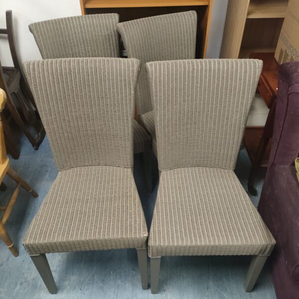 Set of four vintage Lloyd Loom dining chairs with woven seats.