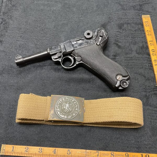 Vintage Luger P-08 pistol with Africa Corps belt, WWII military collectible.
