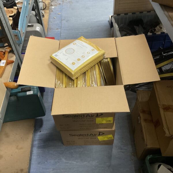 Stack of yellow mailing envelopes in a cardboard box.