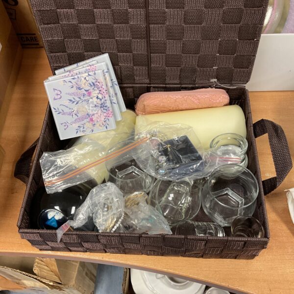 Mixed lot of jewellery and scented candles in a basket.