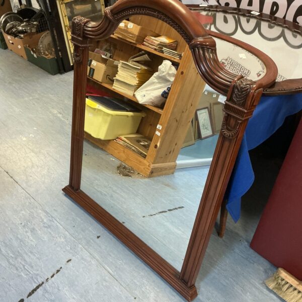 Ornate gilded wall mirror with intricate carvings and a vintage aesthetic.