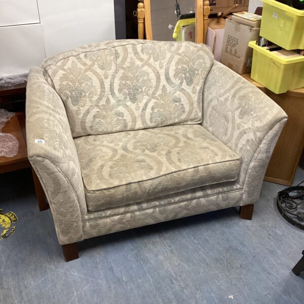 Vintage Parker Knoll snuggle chair in patterned fabric.
