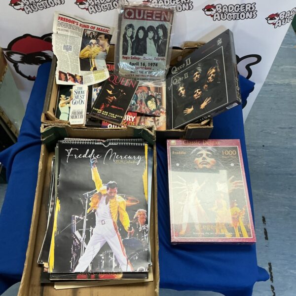 Queen memorabilia lot featuring concert programmes and a jigsaw puzzle.