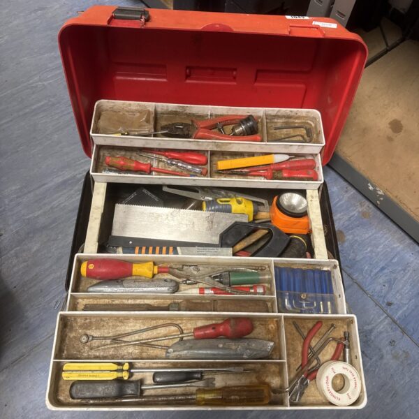 Red plastic toolbox filled with various hand tools for DIY projects.