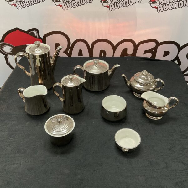 Royal Worcester silver lustre coffee and tea set displayed on a black surface.