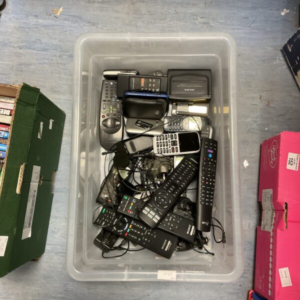 Mixed lot of vintage TV remotes and phones for collectors.