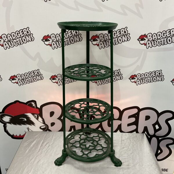 Green cast iron tiered plant stand with claw feet.