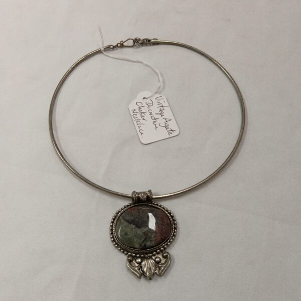 Close-up of a vintage agate choker necklace with green and brown stone.