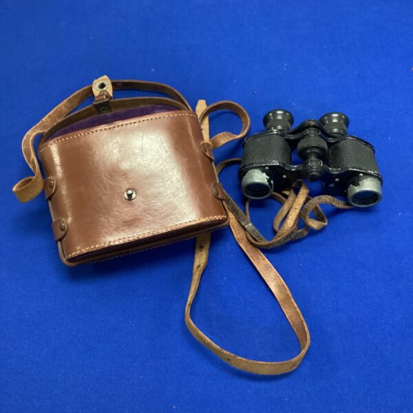 Vintage binoculars in a worn leather case, collectible optics.