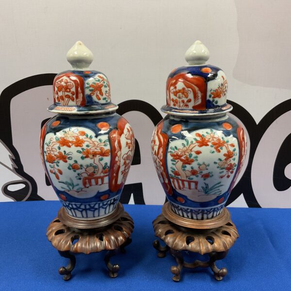 Pair of vintage Japanese Imari temple vases on wooden bases.