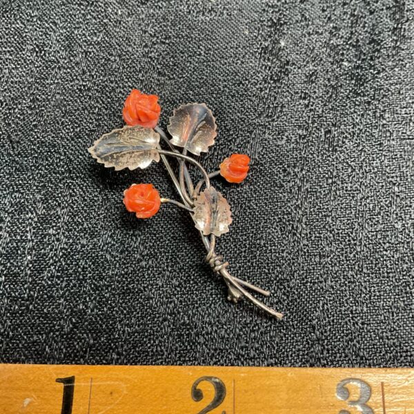 Delicate vintage silver flower brooch with detailed petals.