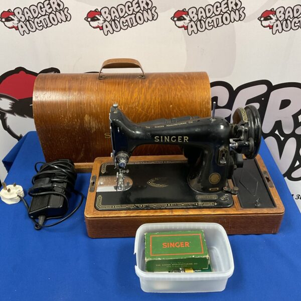 Vintage Singer sewing machine with book and feet.
