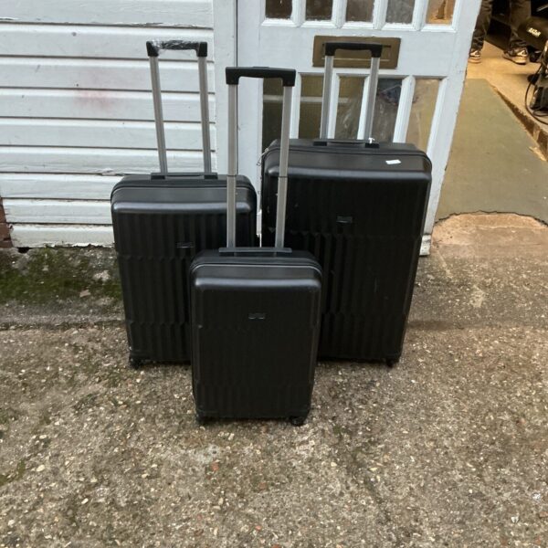 Set of three vintage black hard shell suitcases.