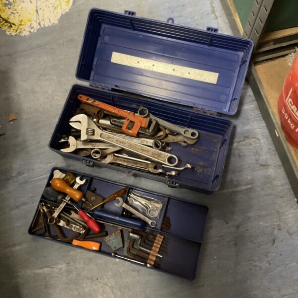 Vintage metal toolbox filled with various hand tools.