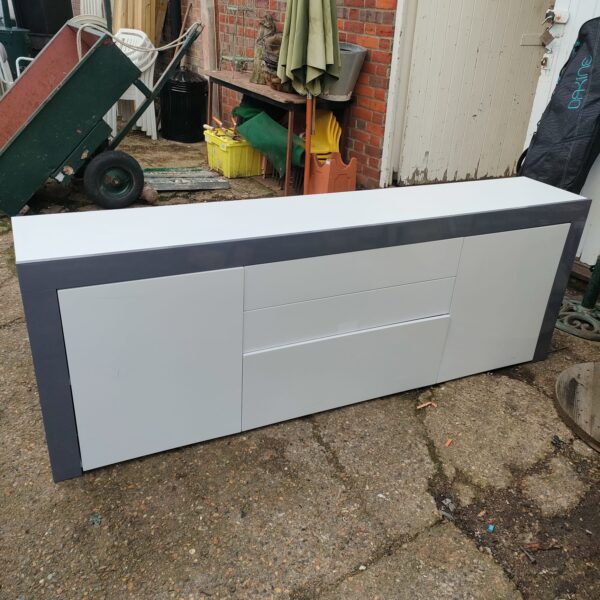 White and grey side unit for storage in a home setting.