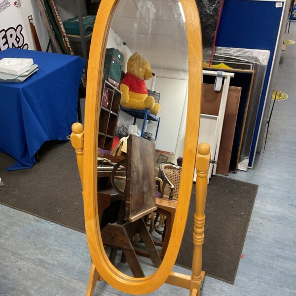 Large antique wooden floor mirror with ornate frame.