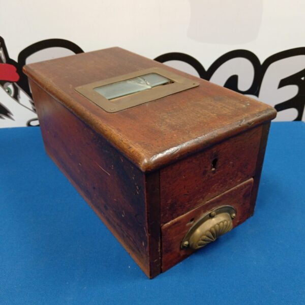 Antique cash register box with wooden construction and glass panel.